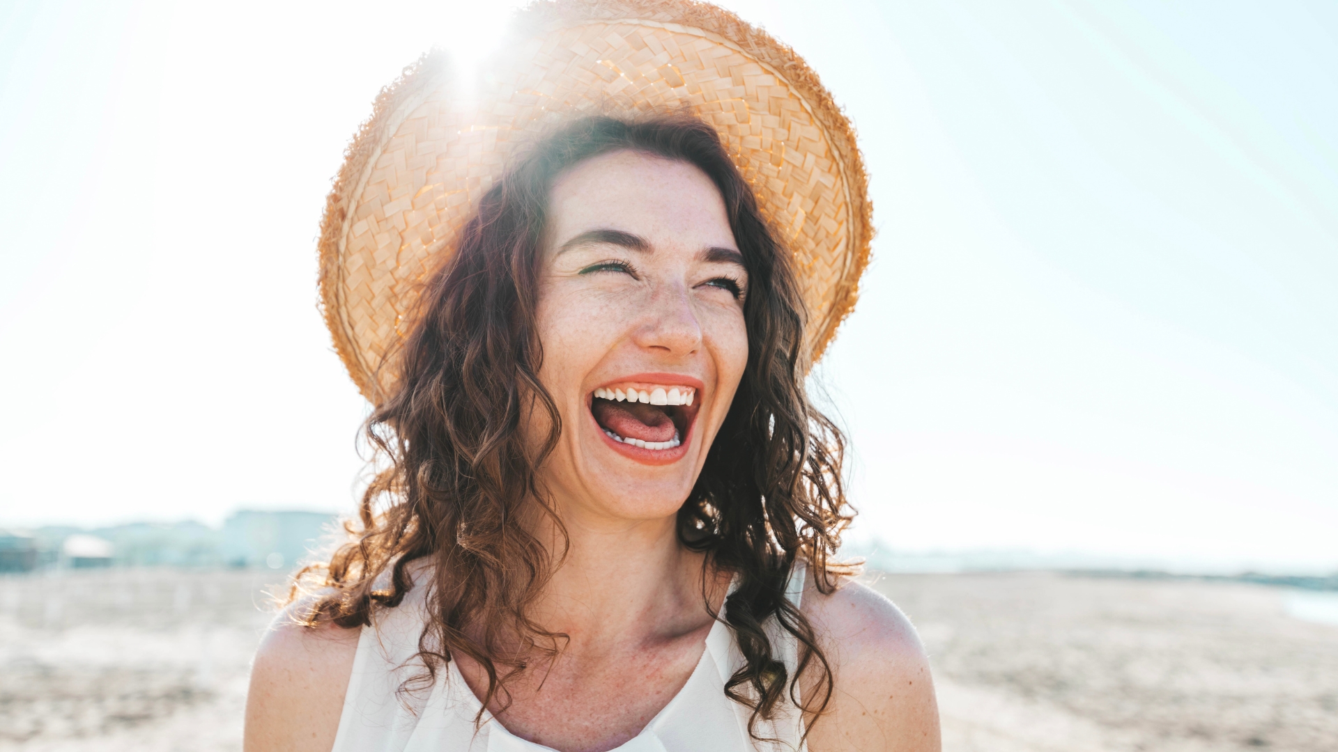 Smiling woman with healthy, radiant skin in the sun